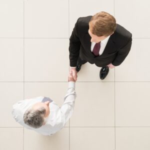 Business partners handshaking. Top view of two business men shaking hands